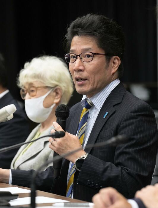 記者会見する拉致被害者家族会の横田拓也代表。左は母早紀江さん＝11日午後、国会