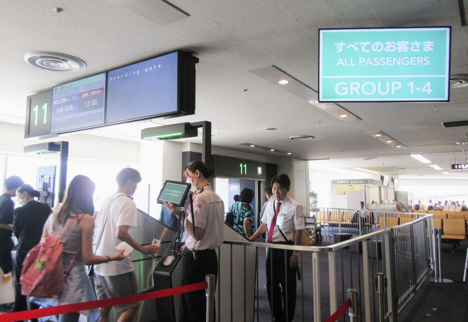 機内混雑を緩和するため、新たな搭乗方法で乗り込む乗客＝11日、羽田空港