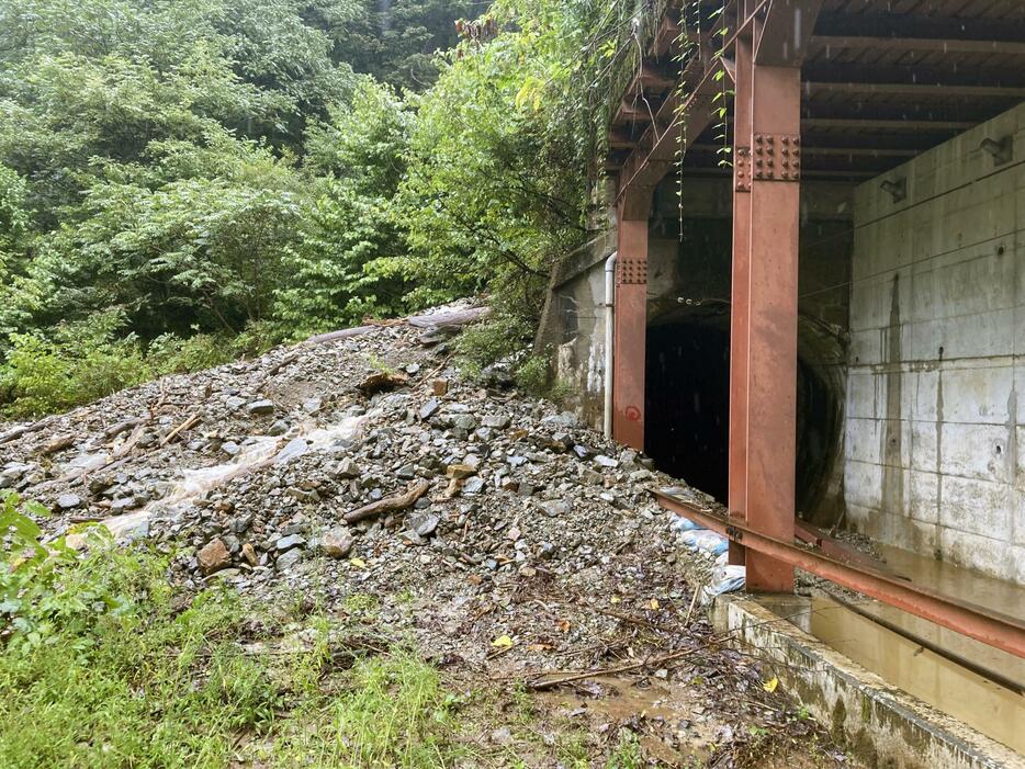 大雨の影響で土砂崩れが起き、黒部峡谷鉄道のトンネル（右）内に土砂が流入した現場＝22日午前11時35分、富山県黒部市（同社提供）