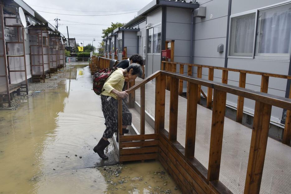 水が引いた仮設住宅の自宅に戻る高齢の女性＝22日午前、石川県珠洲市