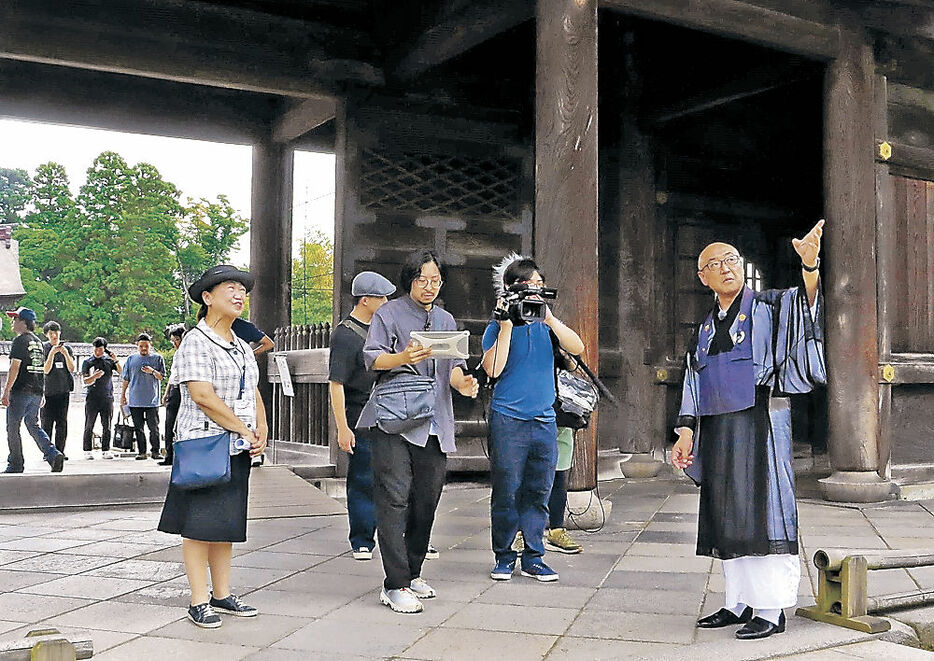 スタッフによる生配信で瑞龍寺を案内する四津谷住職（右）＝高岡市の同寺