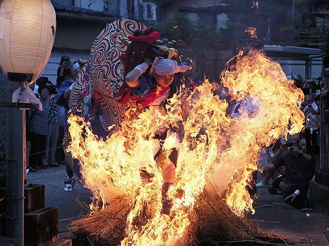 勢いよく炎の中を駆け抜ける獅子＝二口熊野社