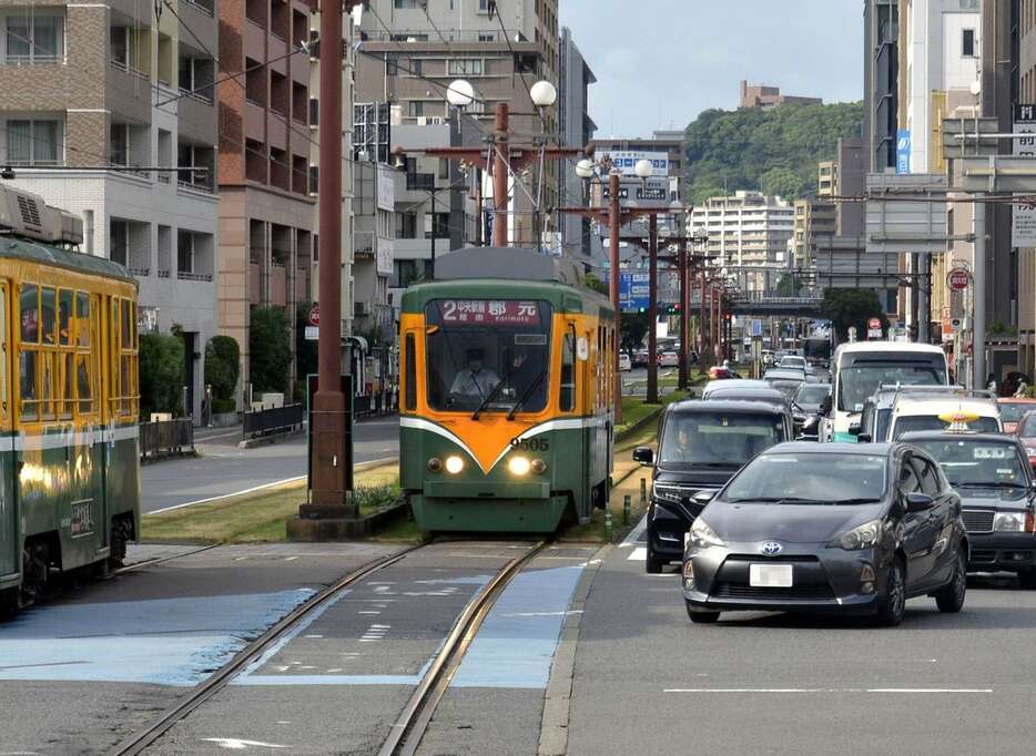 軌道敷の外で市電の通過を待つ右折車両＝鹿児島市の中洲電停交差点（画像は一部加工しています）