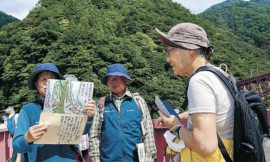 黒部峡谷に伝わる伝説を紹介する解説員＝黒部市宇奈月温泉の山彦橋