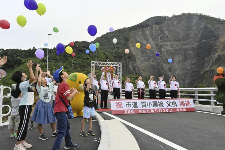 架け替えで新しくなった父橋の完成を祝い、風船を飛ばす参加者＝28日午前、大洲市菅田町大竹