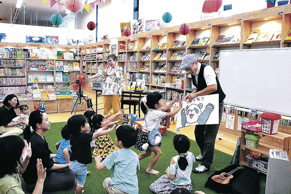 絵本を通して子どもと触れ合うけいたろうさん（右）とひろかわさん＝高岡市の文苑堂書店福田本店