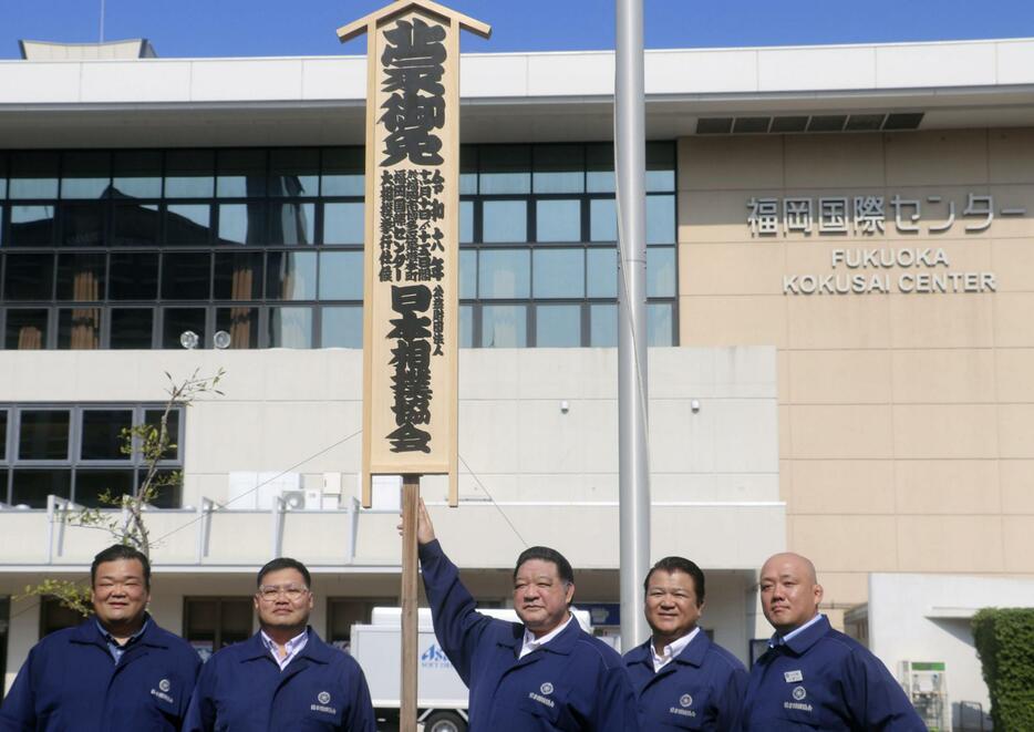 大相撲九州場所の開催を知らせる「御免札」を設置した浅香山親方（中央）ら＝30日、福岡国際センター