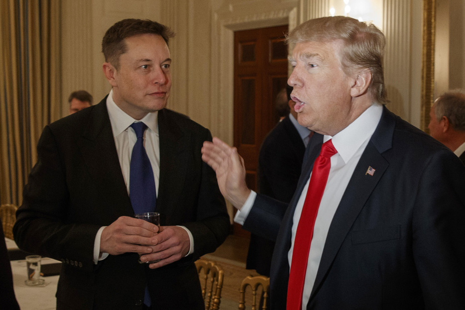 当時米大統領だったトランプ氏（右）と話す電気自動車（EV）大手テスラのイーロン・マスク最高経営責任者（CEO）＝2017年2月、米ホワイトハウス（AP＝共同）