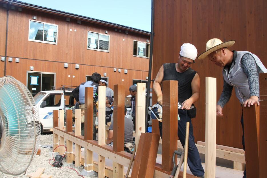 スロープを作る西山さん（中央）。兵庫県丹波篠山市の大工、西家幸男さん（右）、小林俊文さんと同じ工事現場だった。電気と水、トイレがある現場で車中泊する職人も珍しくなかった＝石川県珠洲市大谷町で