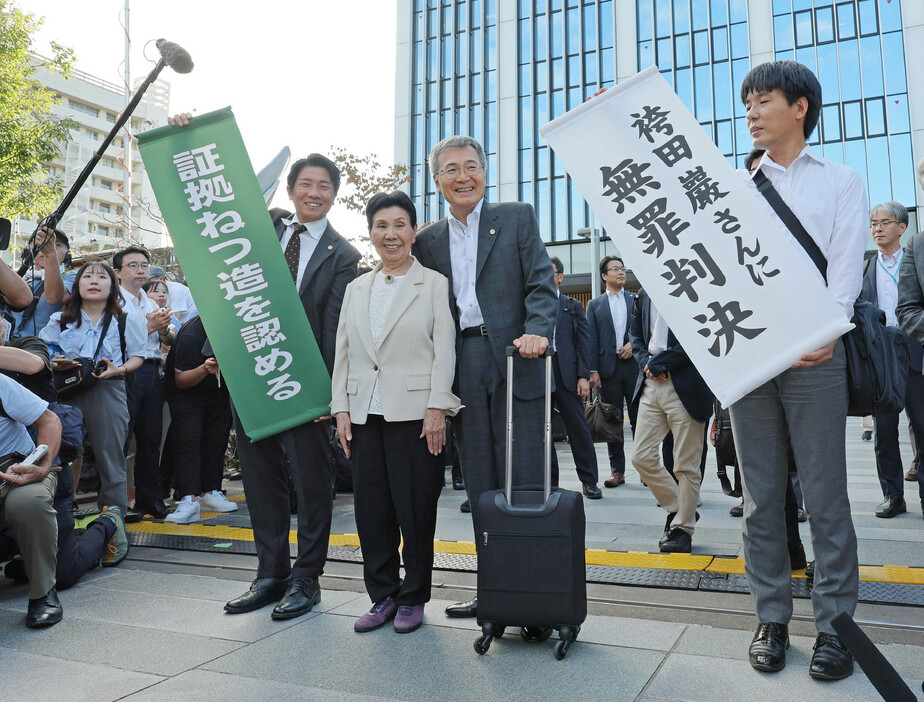 再審判決後、「袴田巌さんに無罪判決」の紙を掲げられ、笑顔を見せる姉ひで子さん（中央左）ら＝２６日午後、静岡市葵区