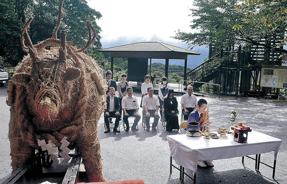 「わらの牛」とともにまつりの成功を祈る実行委員会＝小矢部市の倶利伽羅源平供養塔前