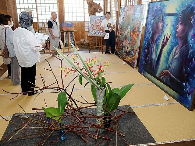 洋画や日本画、油絵と生け花のコラボレーションを楽しむ来場者＝照円寺