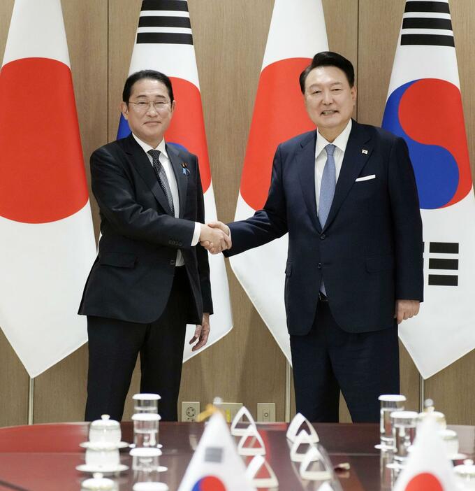 会談を前に韓国の尹錫悦大統領（右）と握手する岸田首相＝6日、ソウルの大統領府（共同）