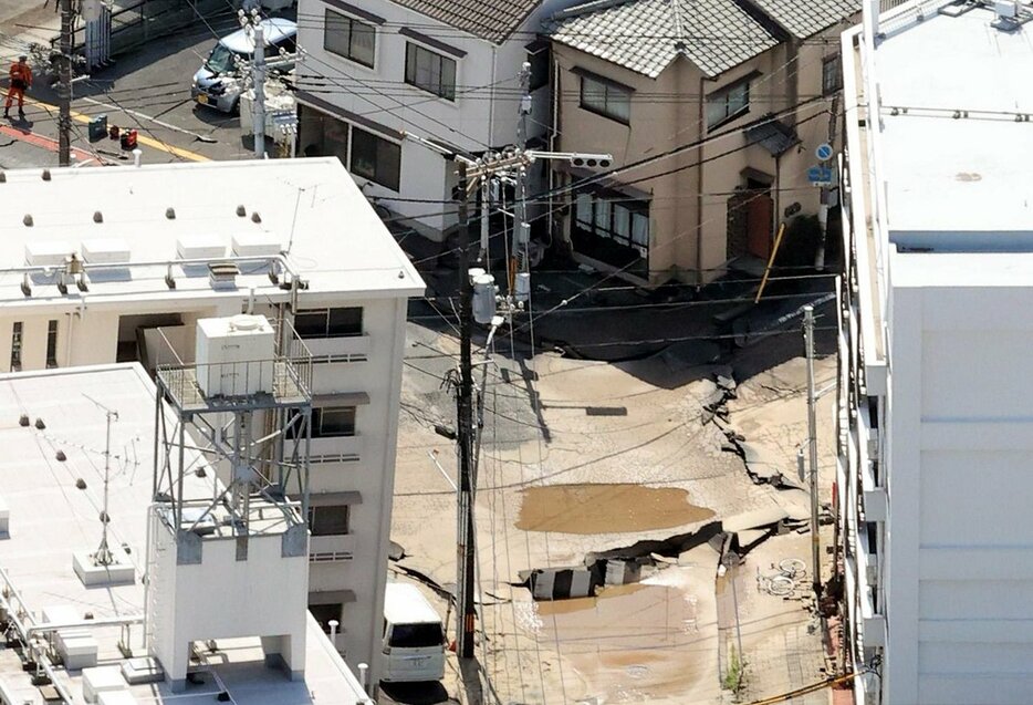 道路陥没が発生し、傾いた住宅