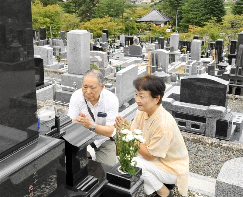 霊前で手を合わせる墓参者