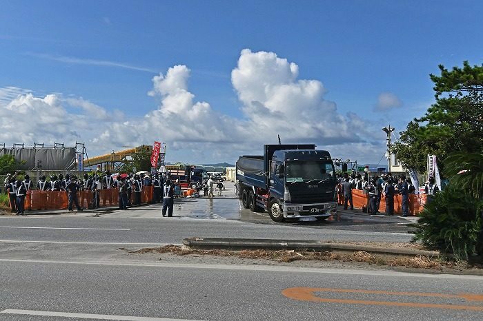 土砂を降ろし国道に出るダンプ＝8月22日、名護市安和（ジャン松元撮影）