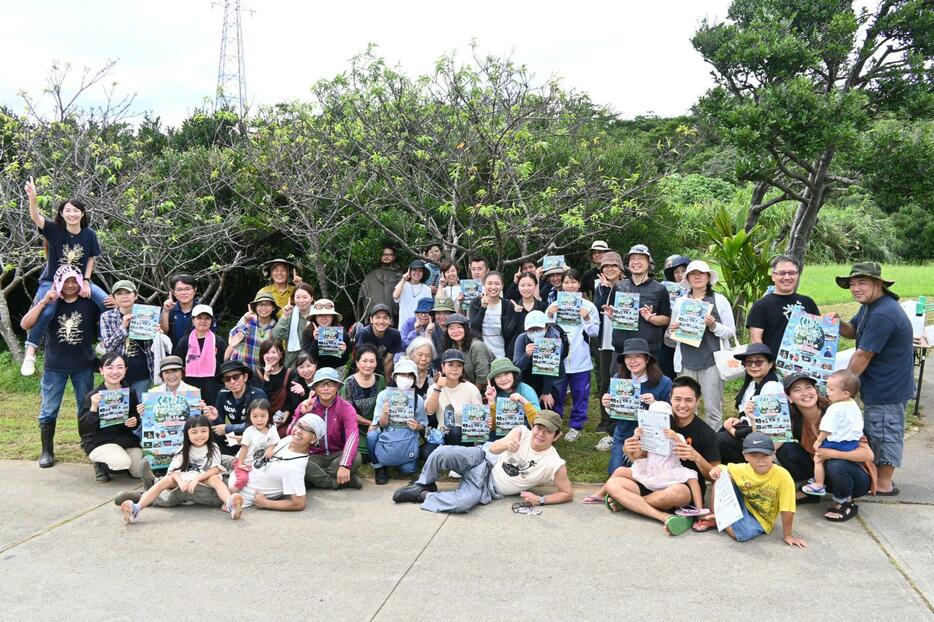 月に一度のくるちの杜の草刈りに参加し、音楽祭への来場を呼びかけるボランティアや実行委員会関係者＝15日、読谷村のくるちの杜