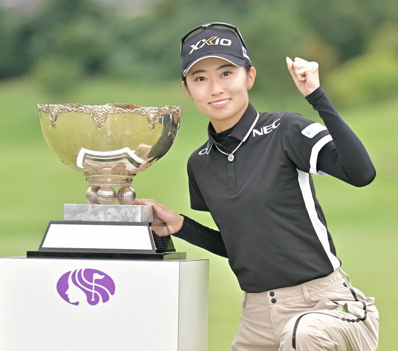 ツアー初優勝を果たしトロフィーと共にガッツポーズで喜ぶ安田祐香（カメラ・今西　淳）