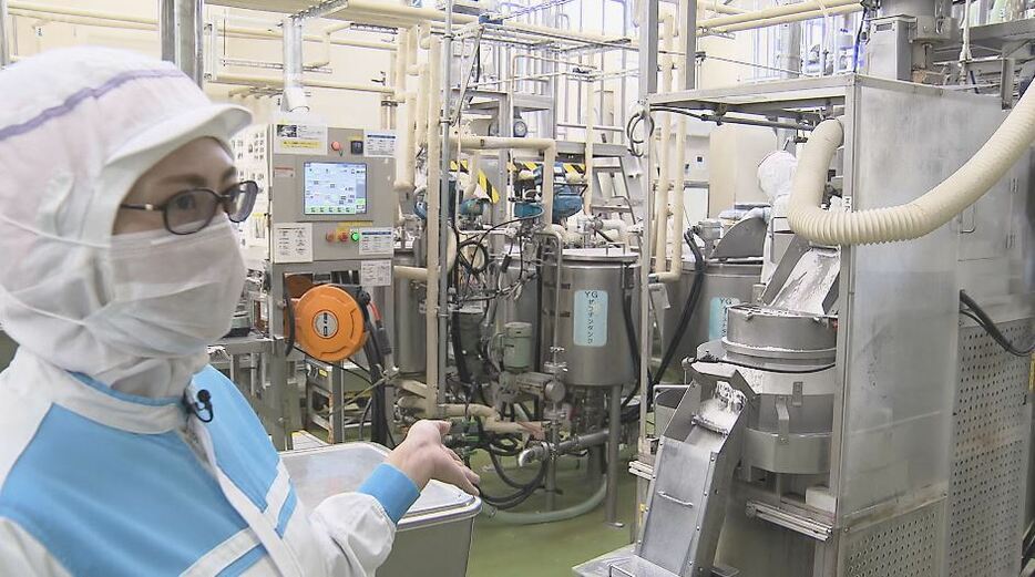 製造ラインを案内するアトリオン製菓 製造部・荻野瑛乃さん