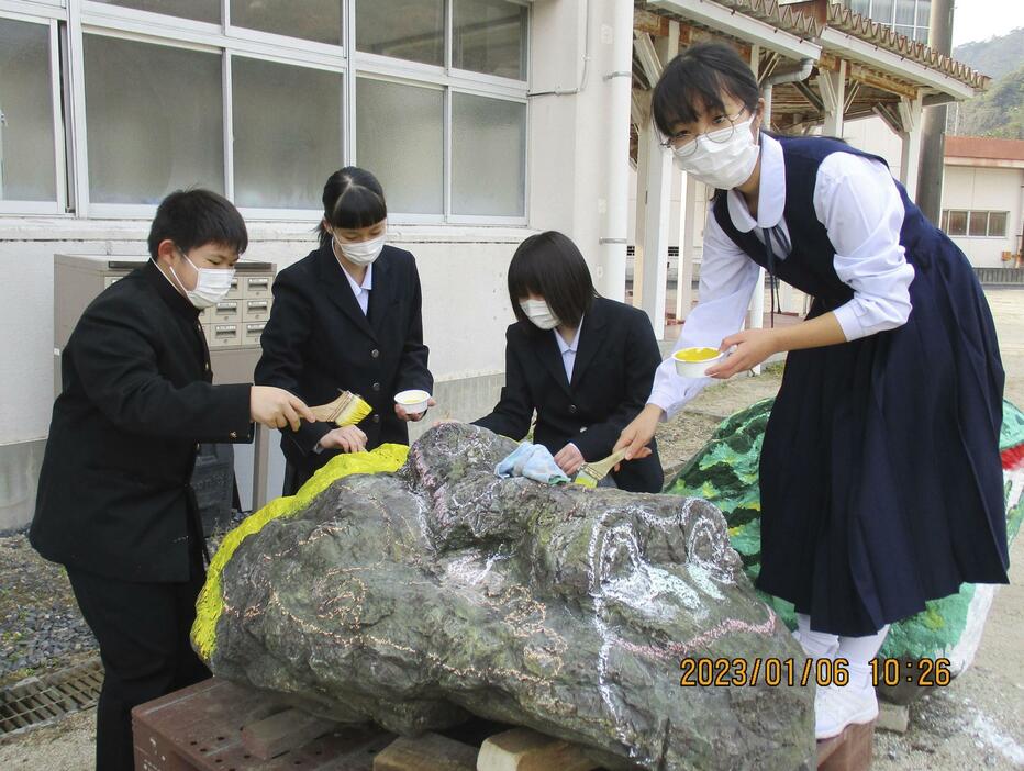 黄色いカエルのストーンアートを制作する広島県大竹市立玖波中の美術部員＝2023年1月、広島県大竹市（同校提供）