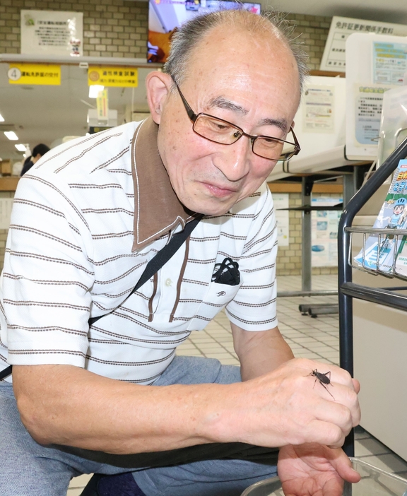 長野中央署に届けたスズムシを手に乗せる片山さん