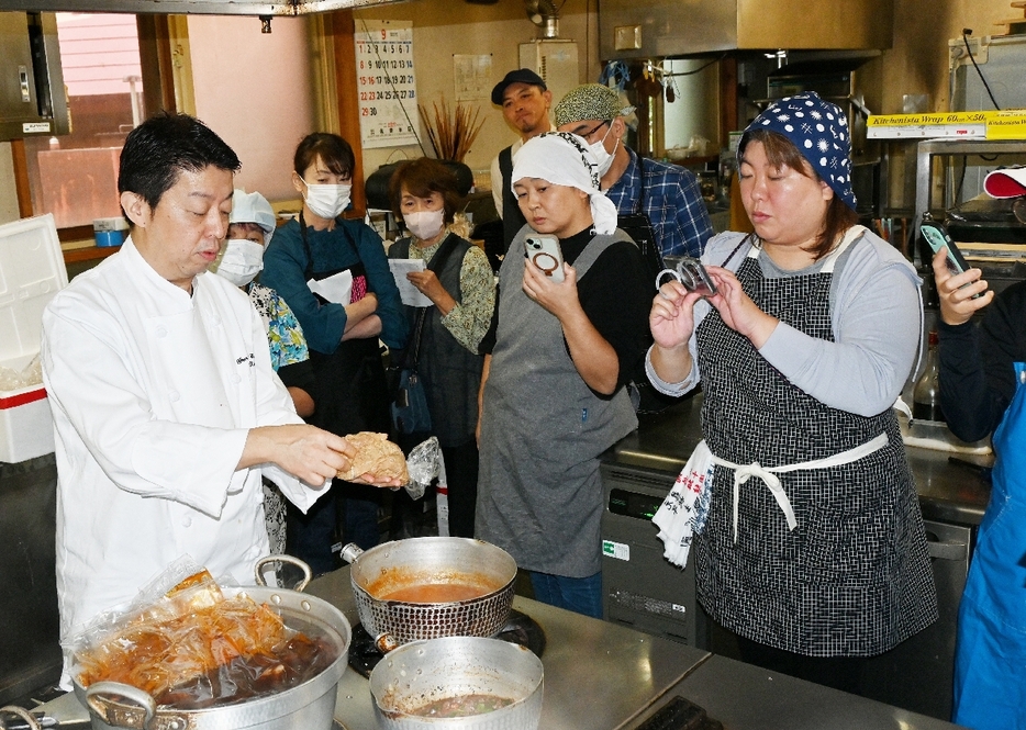 太田高広副総料理長（左）から短角牛料理の作り方を学ぶ参加者