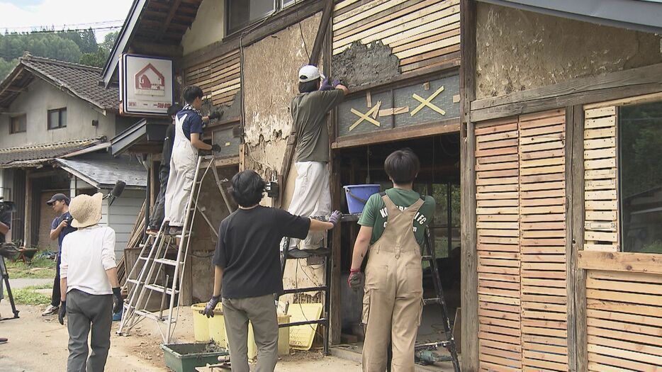 土壁を塗る学生