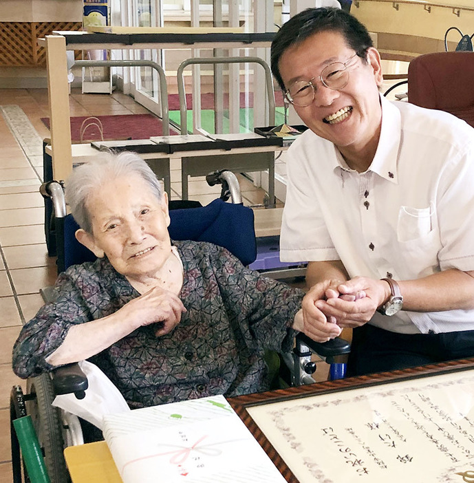 7年ぶりに竹上市長（右）の表敬訪問を受け、笑顔を見せる市内最高齢の錦さん＝山室町のカトレアで