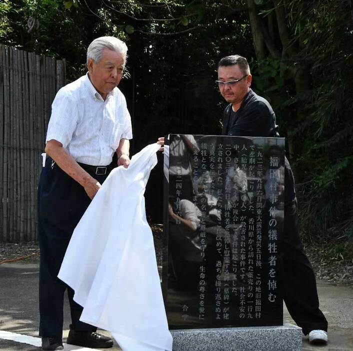 碑文石碑を除幕する市川代表（左）と遺族関係者代表の中嶋さん＝6日、野田市