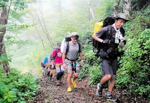 背負子でペットボトルを背負い、エイドまで運ぶ参加者=9月1日、福井県おおい町名田庄染ケ谷