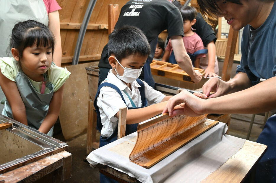 丁寧に作業をする参加者＝伊豆市修善寺の紙谷和紙工房