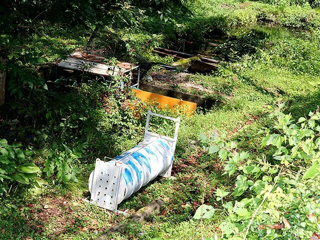 親グマがかかっていたわな（手前）と養魚場（右奥）＝南砺市大島