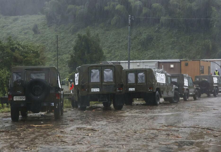 土砂流出があった石川県輪島市の国道249号中屋トンネル付近で待機する自衛隊車両＝22日午前7時3分