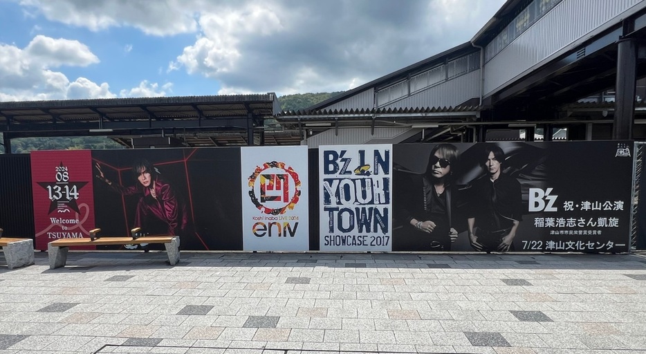 「Koshi Inaba LIVE2024～enⅣ～」と「B’z SHOWCASE 2017 -B’z In Your Town-」の看板が並んだJR津山駅=岡山県津山市で