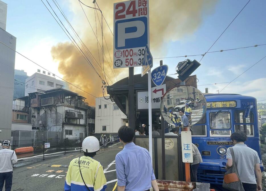 長崎市で起きた集合住宅火災の現場付近。手前は長崎電気軌道の崇福寺電停＝9日午前7時37分