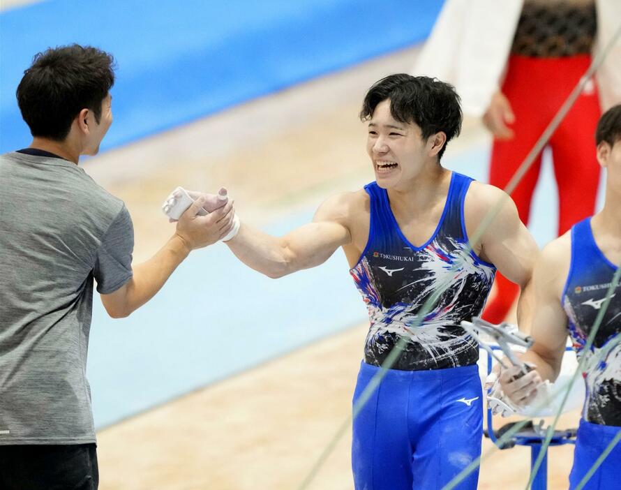 鉄棒の演技を終え笑顔の岡慎之助。男子個人総合で優勝した＝アリーナ立川立飛