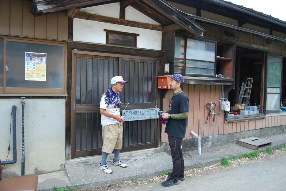 改修中の古民家「カモン」の前で話す柴田恵樹さん（右）と元所有者の小池清史さん＝上伊那郡箕輪町