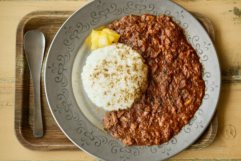 「飯田のカレー（フル）」1,100 円。〈飯田商店〉のスープの二番だしを使用。スパイシーながら、フルーティな風味も「ヤミツキになる」とファンを増やしている理由。