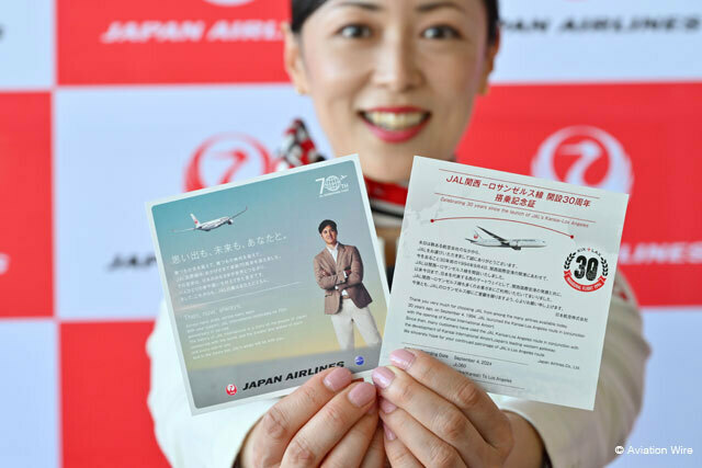 関空の30番搭乗口でJAL関西－ロサンゼルス線30周年を記念した大谷選手の搭乗記念証を手にする客室乗務員＝24年9月4日 PHOTO: Tadayuki YOSHIKAWA/Aviation Wire