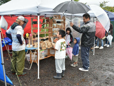 雑貨や食の出店者を巡る家族連れ