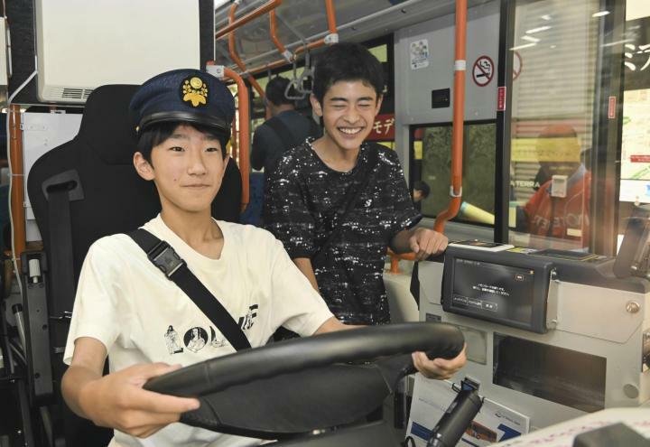 公共交通利用促進イベントでバスの運転席を体験する中学生