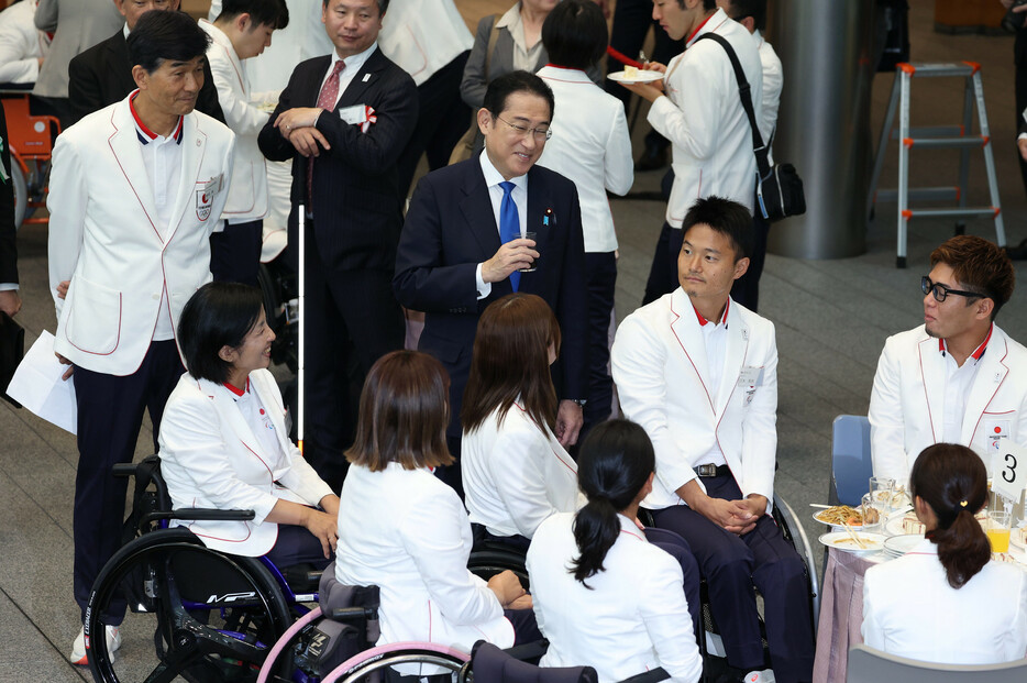 岸田文雄首相は１１日、パリ五輪・パラリンピック選手団を首相官邸に招き、感謝状や銀製写真立てを贈った。五輪体操男子で３冠を達成した岡慎之助選手らが参加。写真はパラ日本代表の選手と懇談する岸田首相（中央）