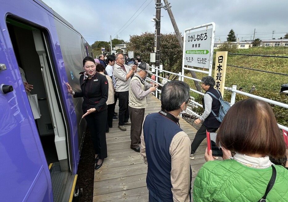 「日本最東端の駅」看板で記念撮影をするひとめぐり号の乗客（28日午前11時50分ごろ）