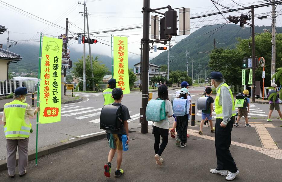 子どもたちの登校を見守りながら街頭啓発活動を行う松代安協の役員ら＝7月18日、長野市松代町の東条小学校前交差点