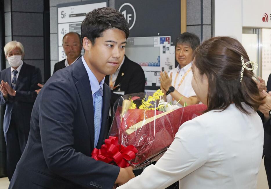 初当選した秋田県大館市長選から一夜明け、市役所で花束を受け取る石田健佑氏＝2日午前