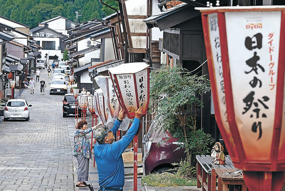 越中八尾おわら風の盆に向け、ぼんぼりを取り付ける住民＝３１日午後１時半、富山市八尾町諏訪町