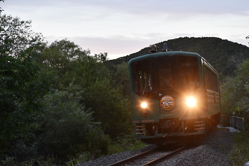 オレンジ色の空を背に走る夕陽ノロッコ号（21日午後5時15分ごろ、細岡駅付近）