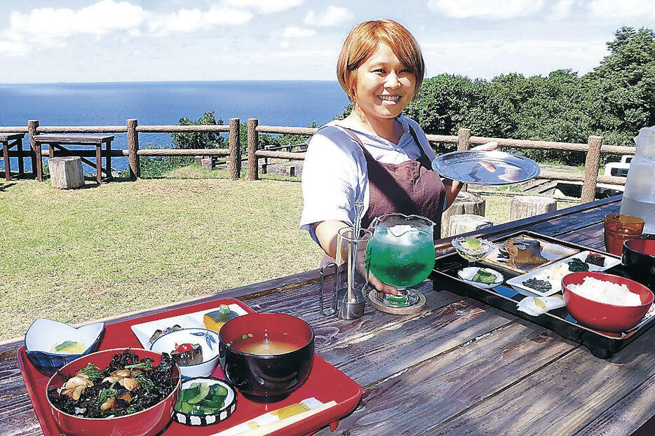 絶景を望む席で海の幸の料理を提供する番匠さん=珠洲市折戸町のつばき茶屋