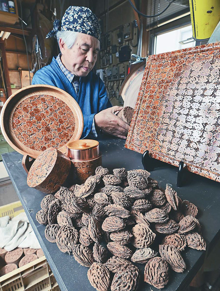 桃の種を生かした工芸作品を制作して50年の鴨田さん（山形県大江町で）