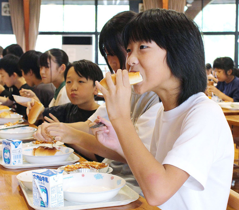 おいしそうにパンを食べる子供たち＝大台町茂原の宮川小で